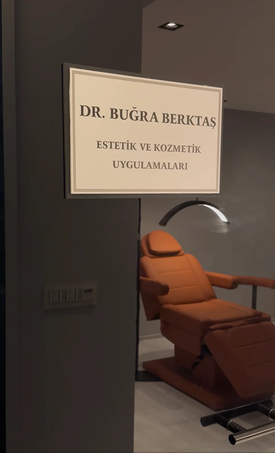 Табличка Dr. Buğra Berktaş на двери и процедурное кресло